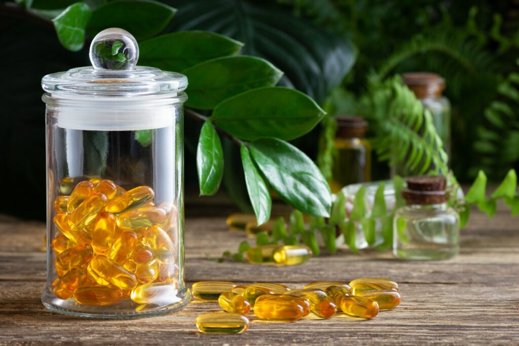Omega gelatin capsules in a glass transparent jar. Nutritional supplement - vitamin D.